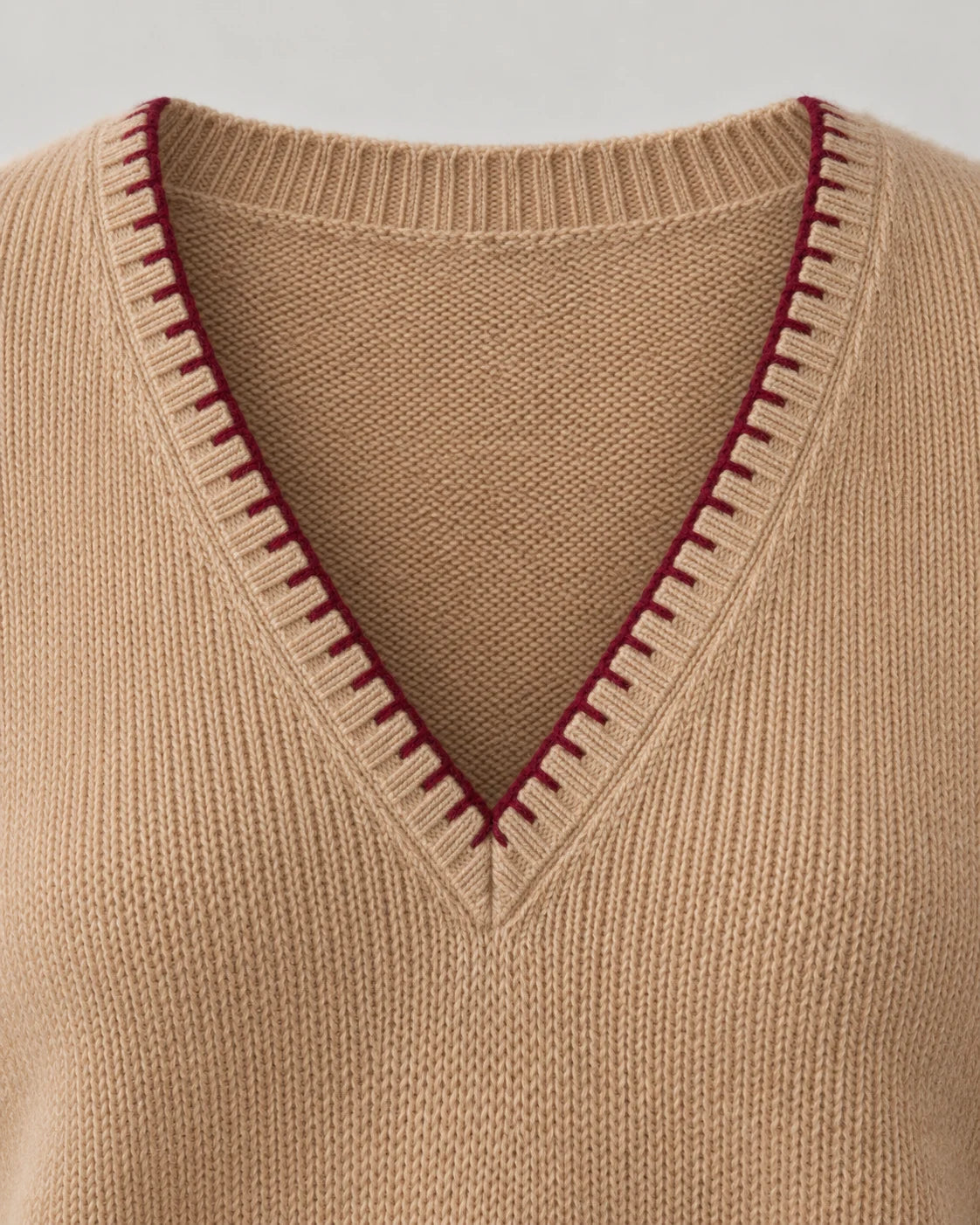 Burgundy blanket stitches following a cashmere V-neck