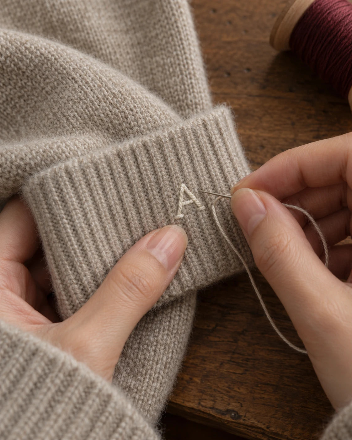 Careful stitches on a cashmere cuff